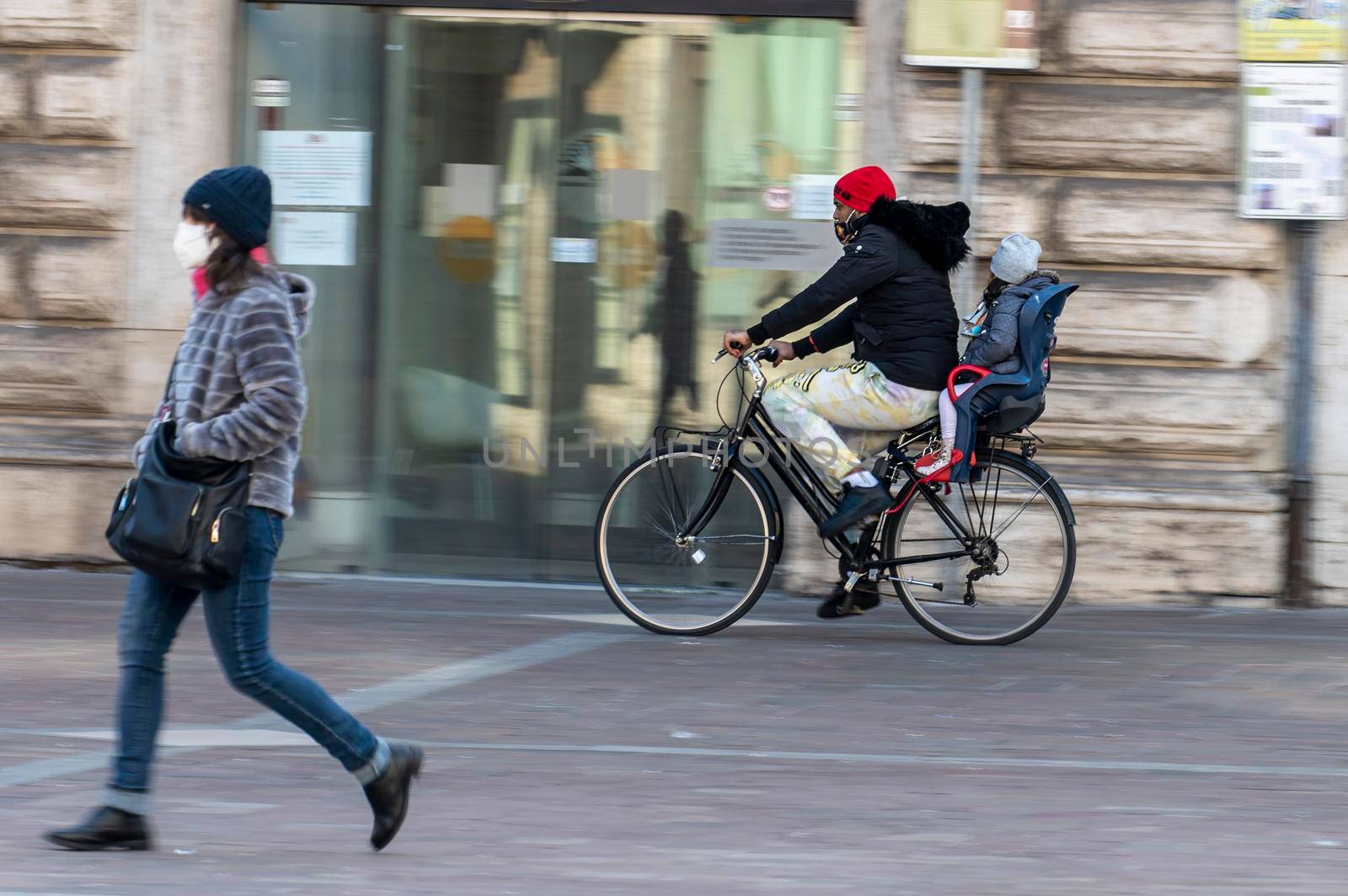 terni,italy february 19 2021:man panning girl on bicycle downtown