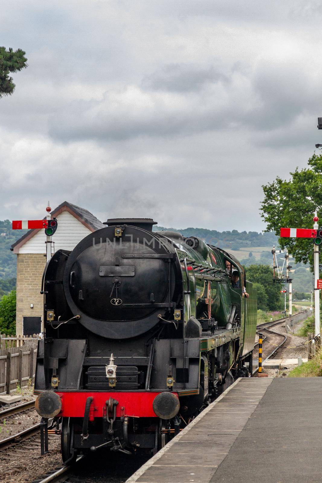 An old iron steam locomotive in a countryside station