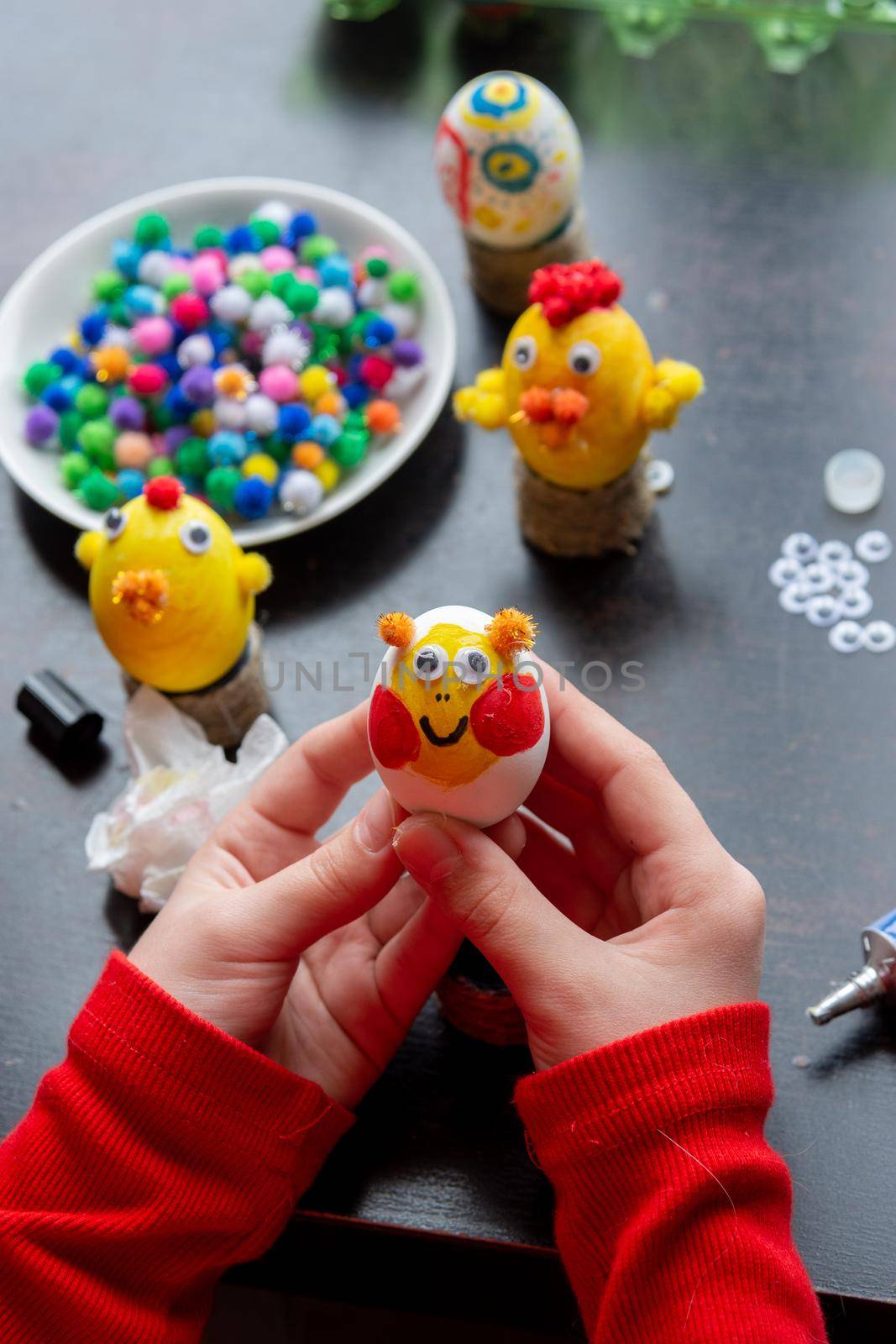 Child's hands hold a painted egg as a gift to celebrate easter