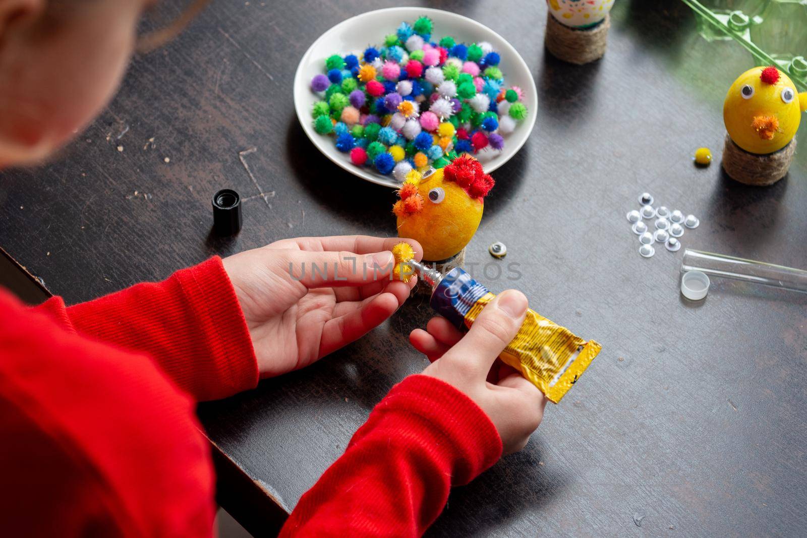 a girl in the workshop makes crafts from eggs for the Easter holiday