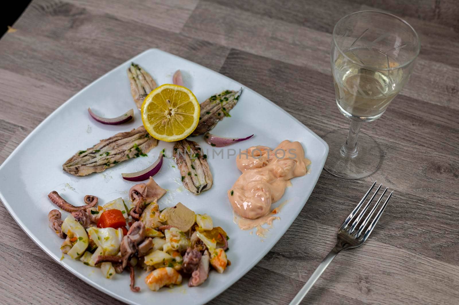 appetizer with seafood goblet of wine and cutlery on wooden background