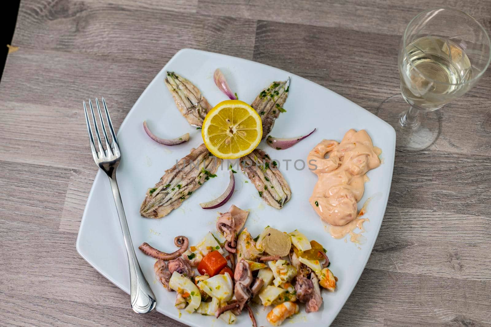 appetizer with seafood goblet of wine and cutlery on wooden background