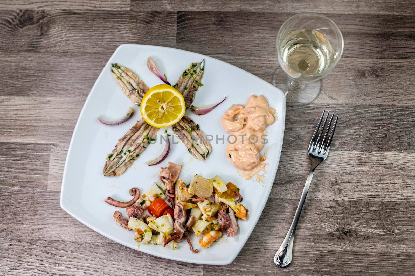 appetizer with seafood goblet of wine and cutlery on wooden background