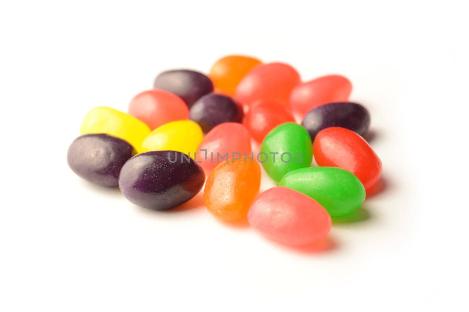 A handful of jelly bean candy isolated over a white background.