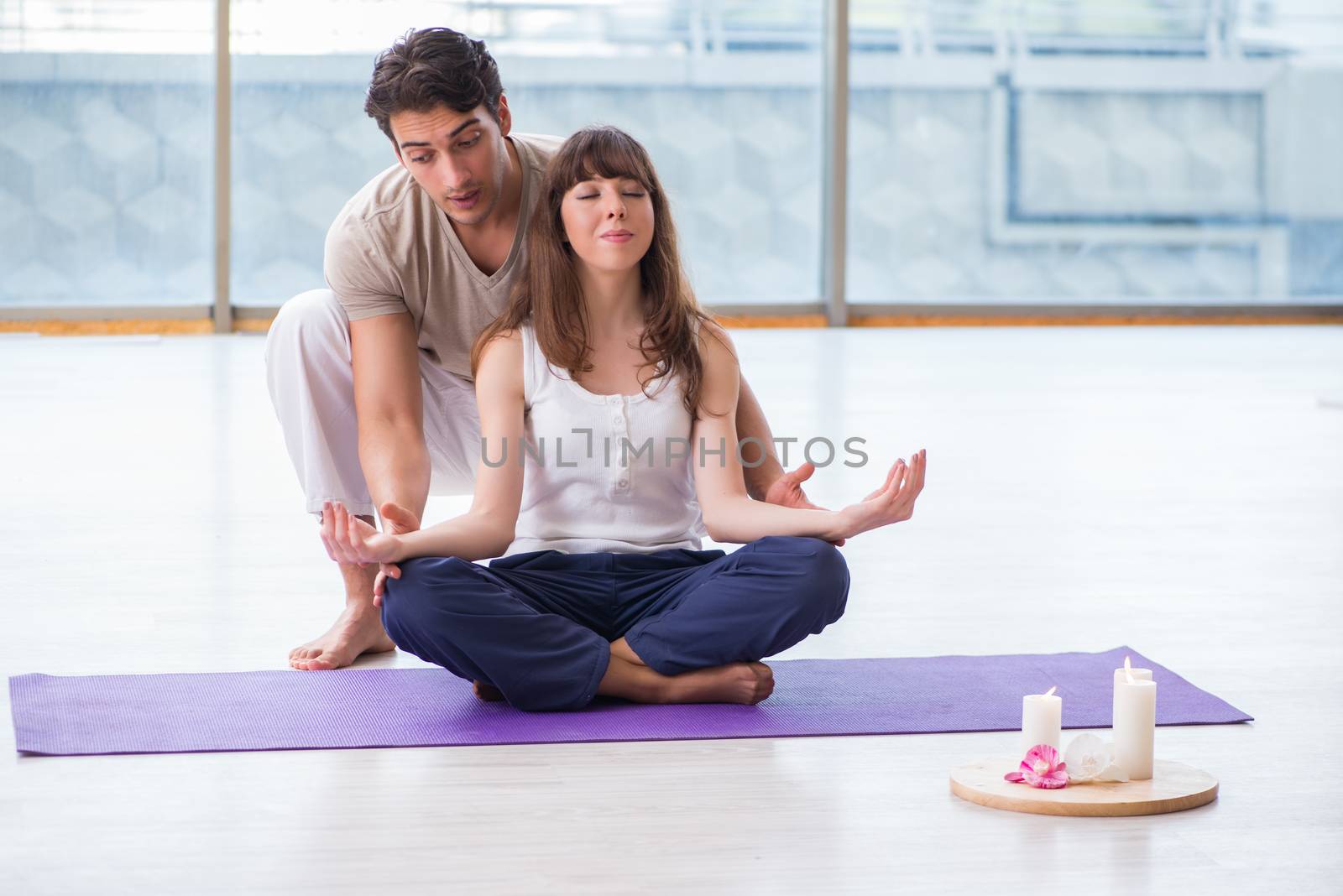 Personal coach helping during yoga session by Elnur