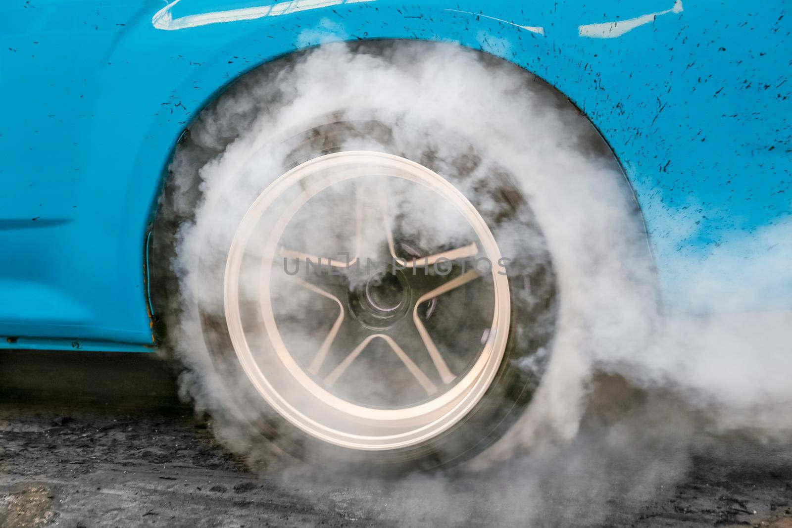 Drag racing car burns rubber off its tires in preparation for the race