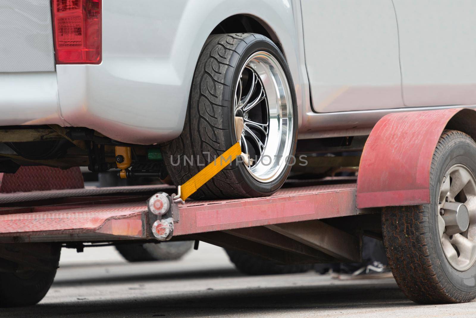 Small trailer transports car on the road