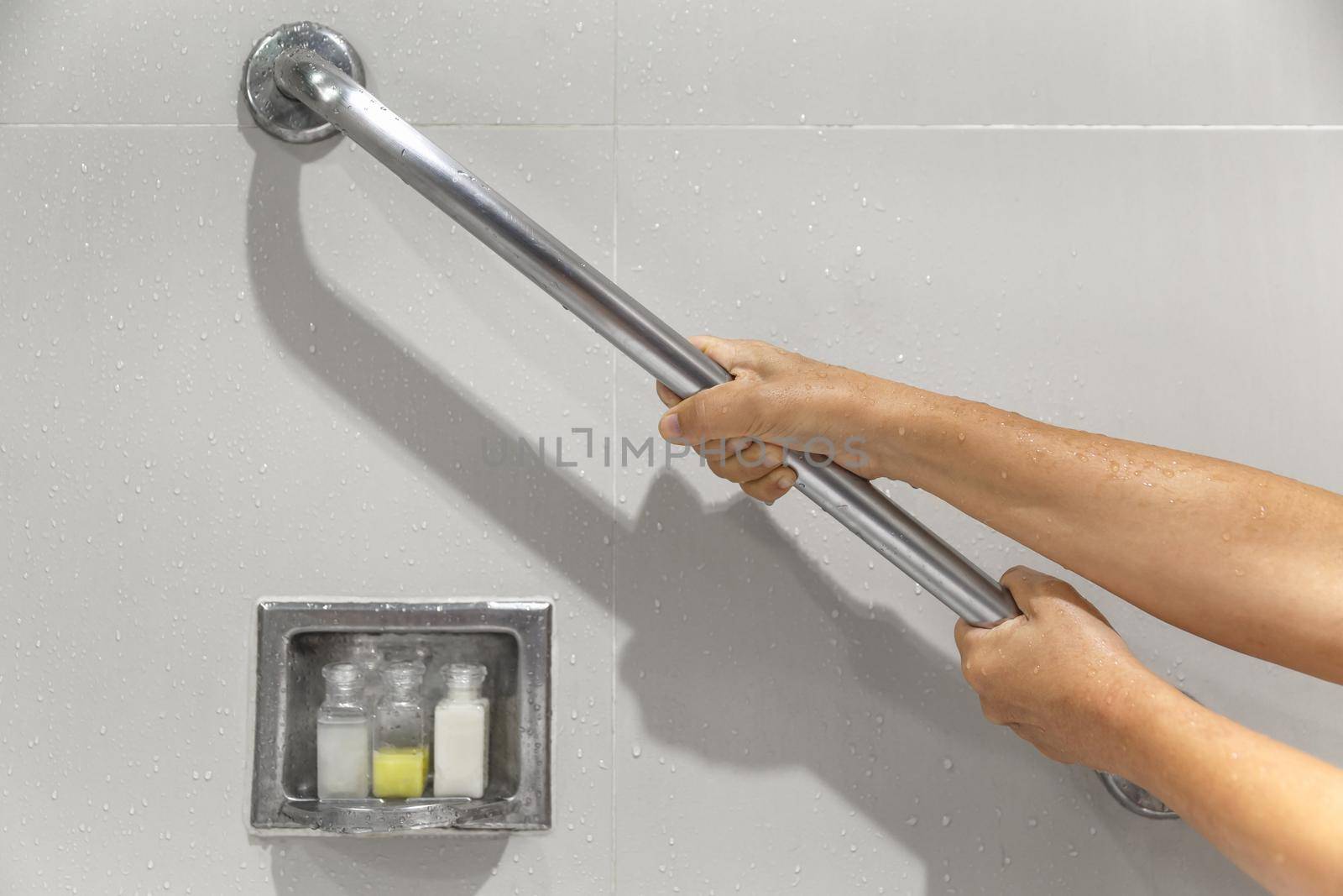 Senior woman holding on handrail for safety in bathroom