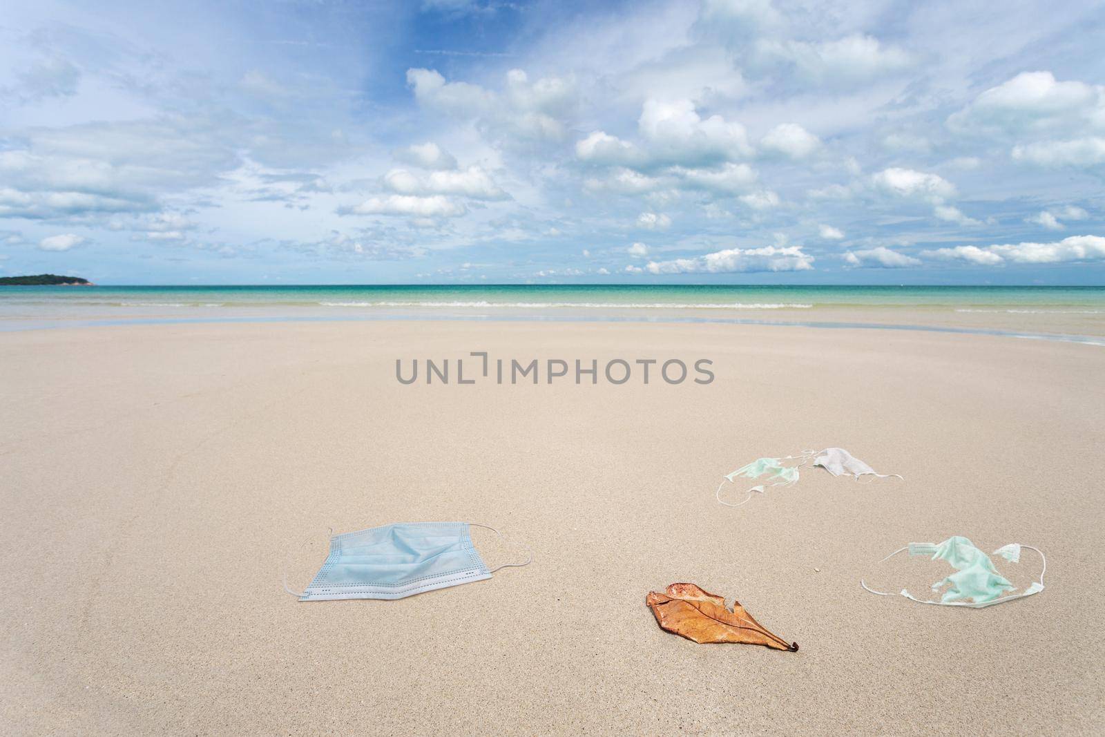 Garbage from used medical masks on the beach.