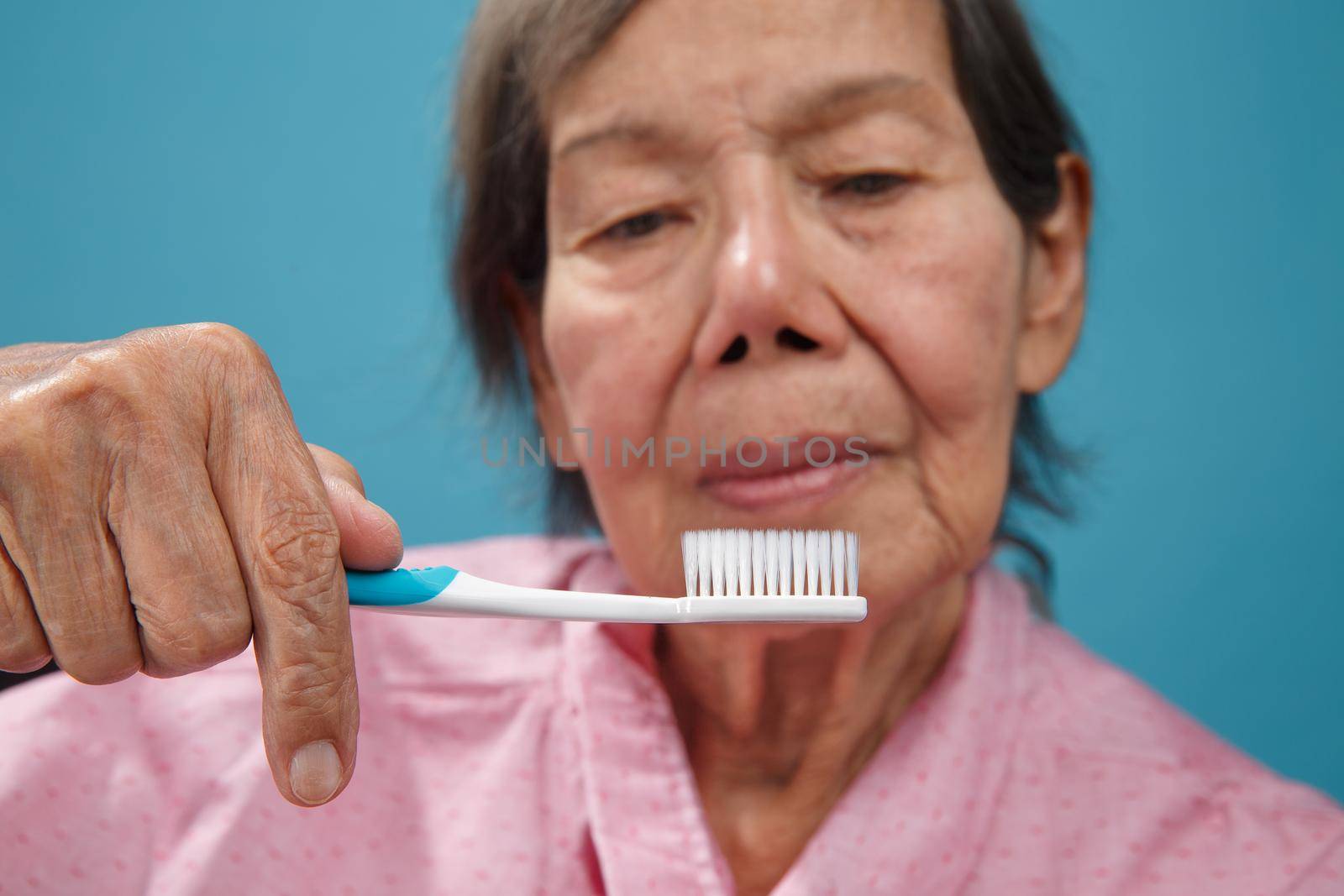 asian elderly woman using toothbrush. by toa55