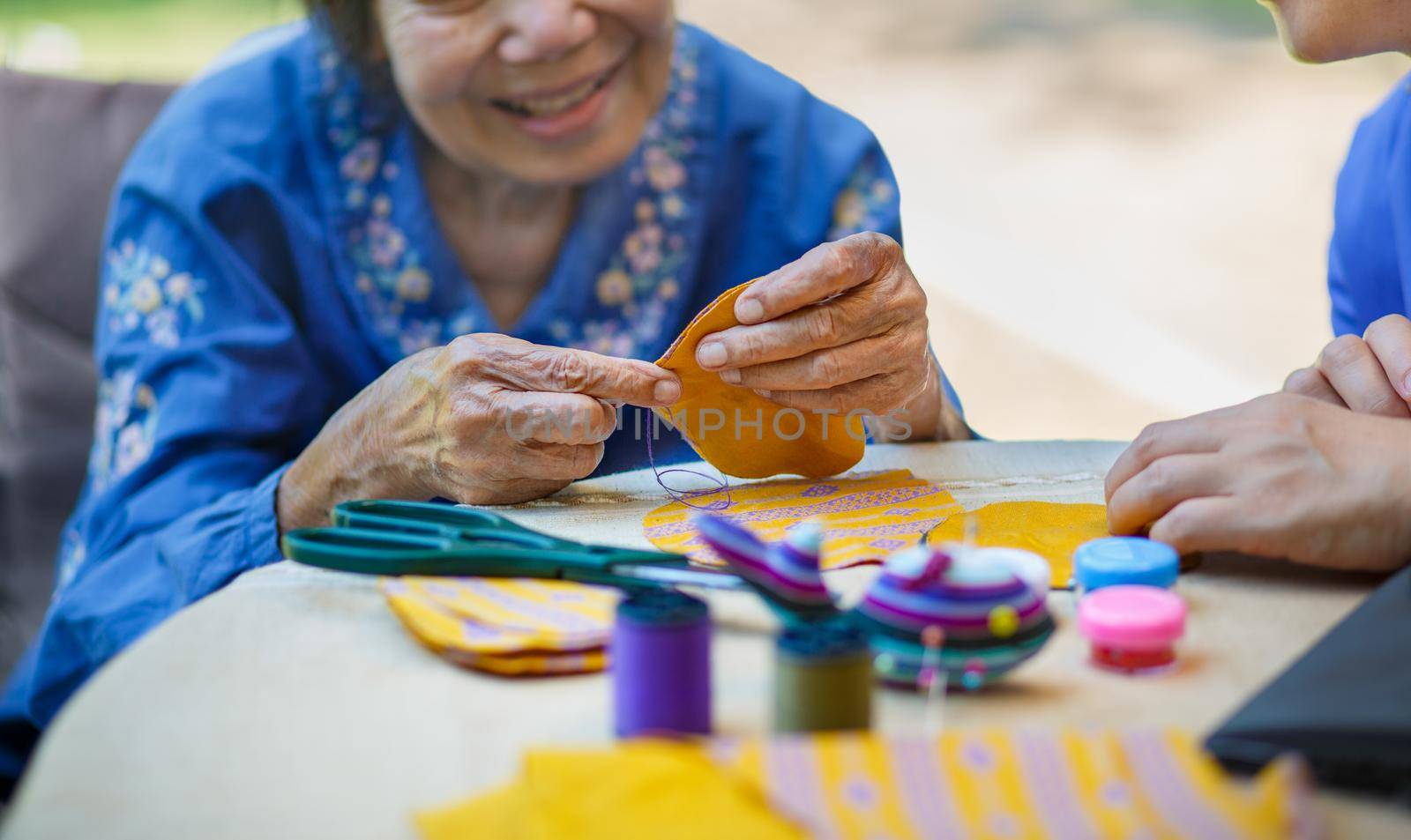 Elderly woman with caregiver in the needle crafts occupational therapy  for Alzheimer’s or dementia by toa55