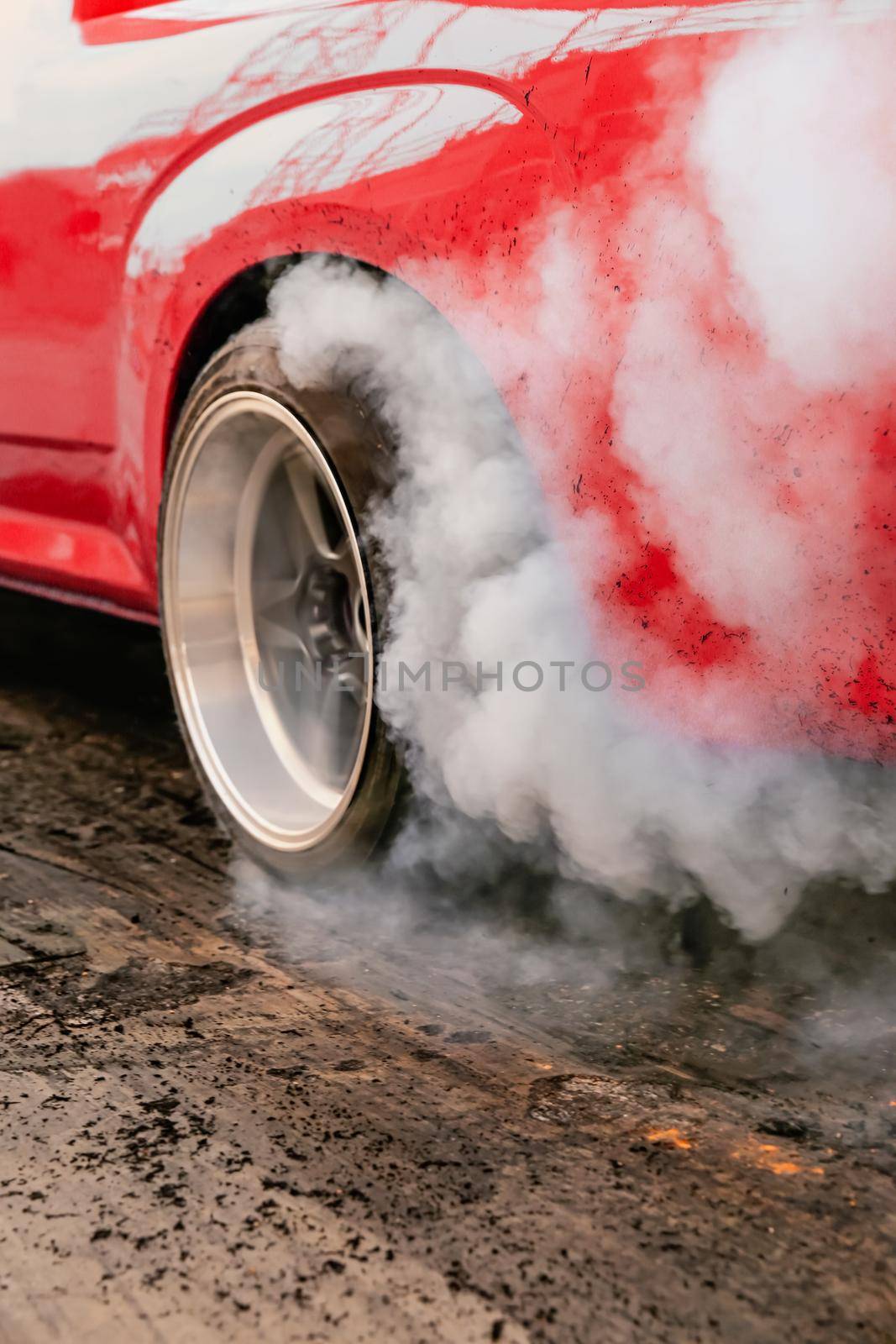 Drag racing car burns rubber off its tires in preparation for the race