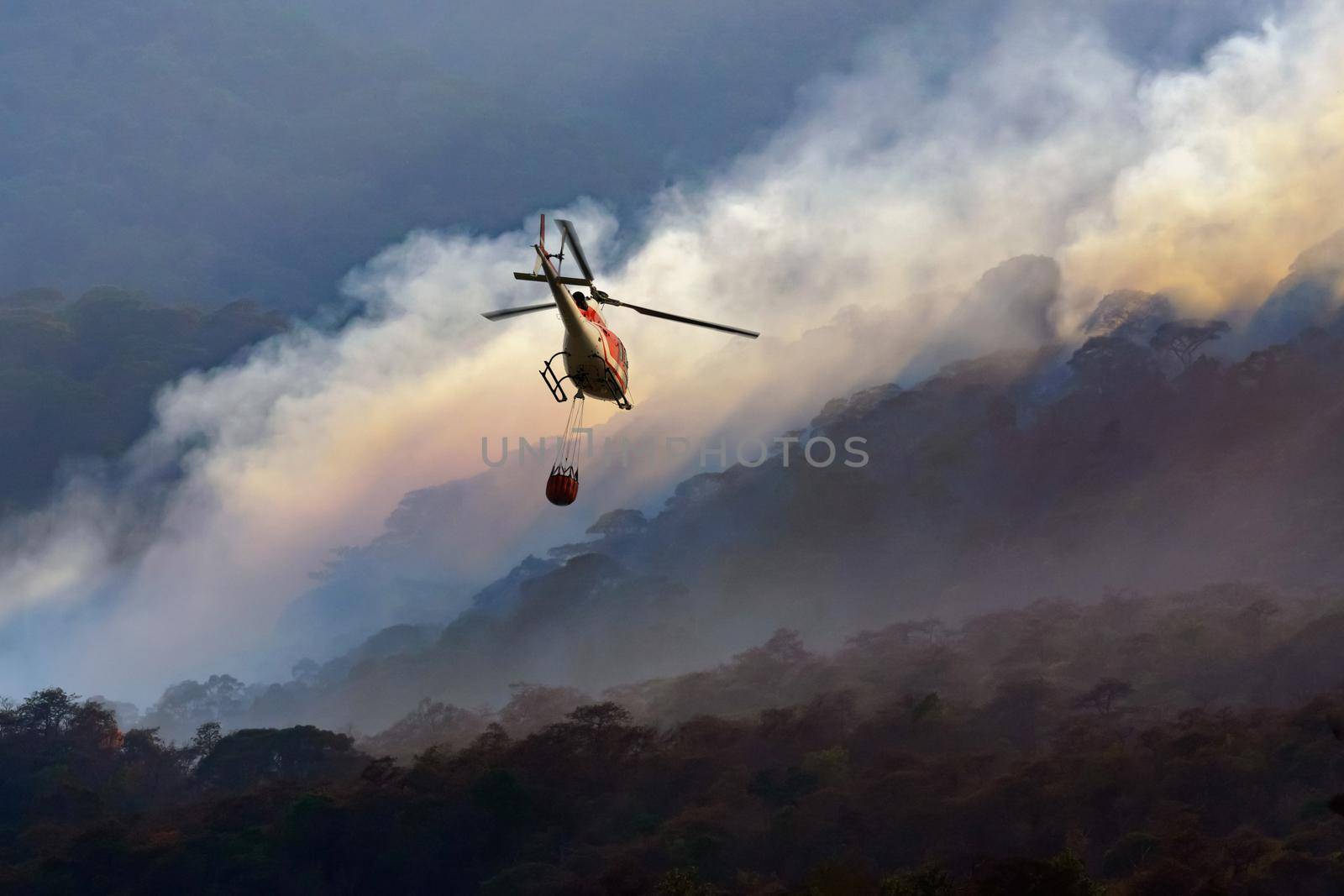 Fire fighting helicopter carry water bucket to extinguish the forest fire by toa55