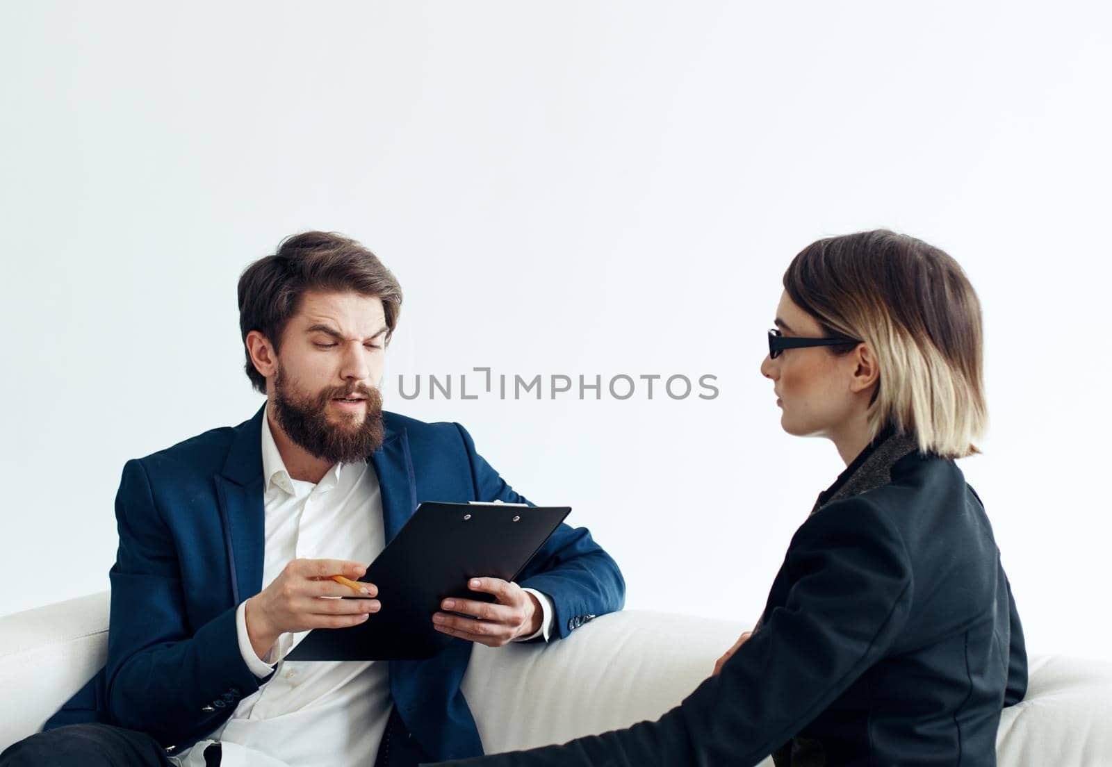 Business man and woman employees communicating on the couch indoors. High quality photo