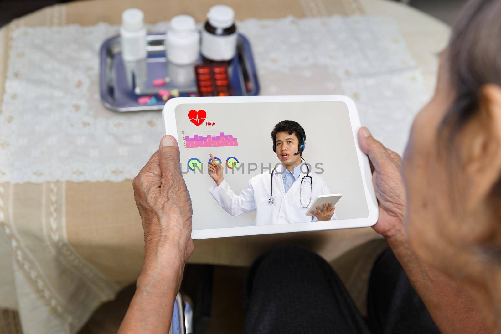 Elderly woman sit at home having online consultation with doctor on tablet computer. by toa55