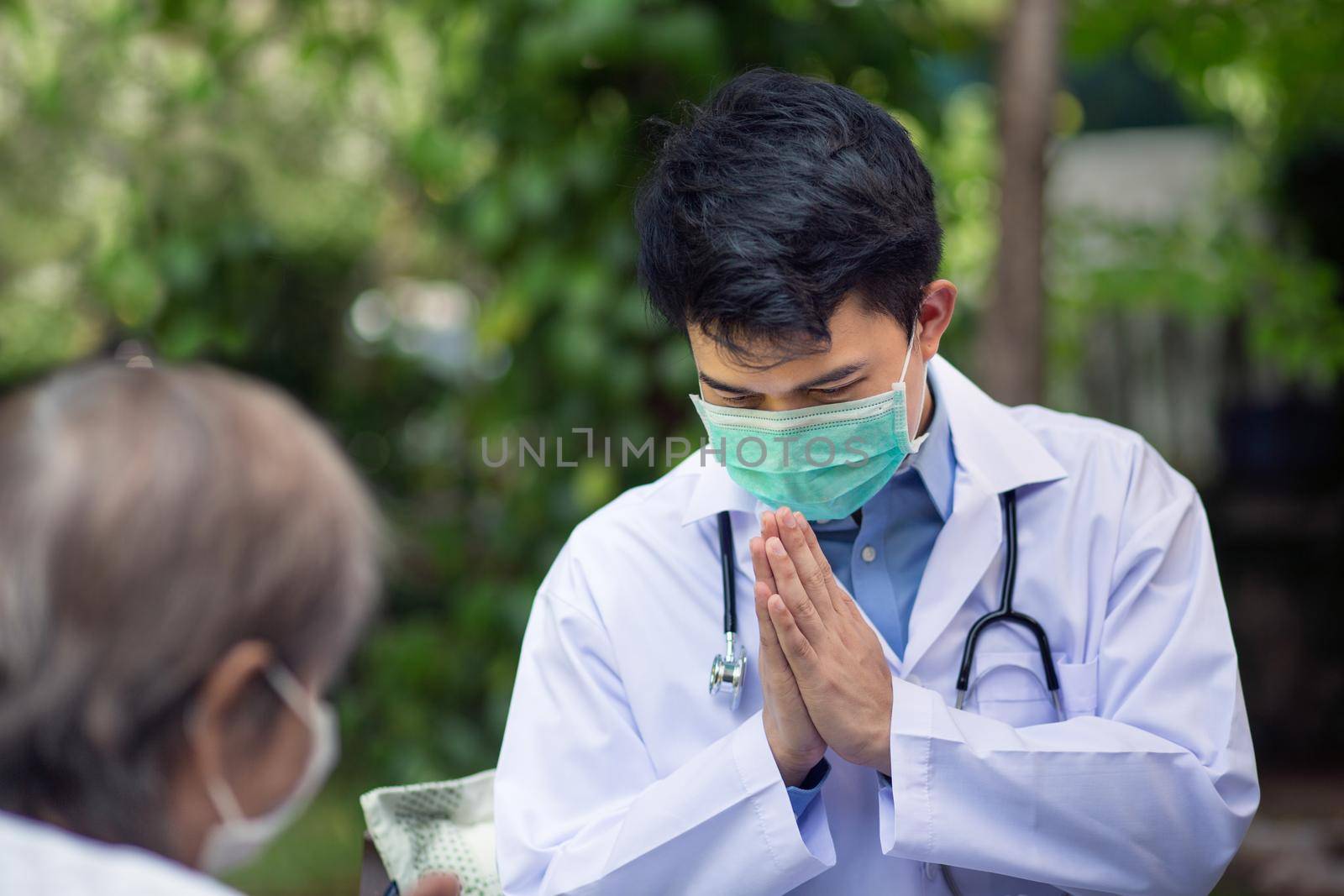 Thai Doctor greeting (wai) senior patient in wheelchair by toa55