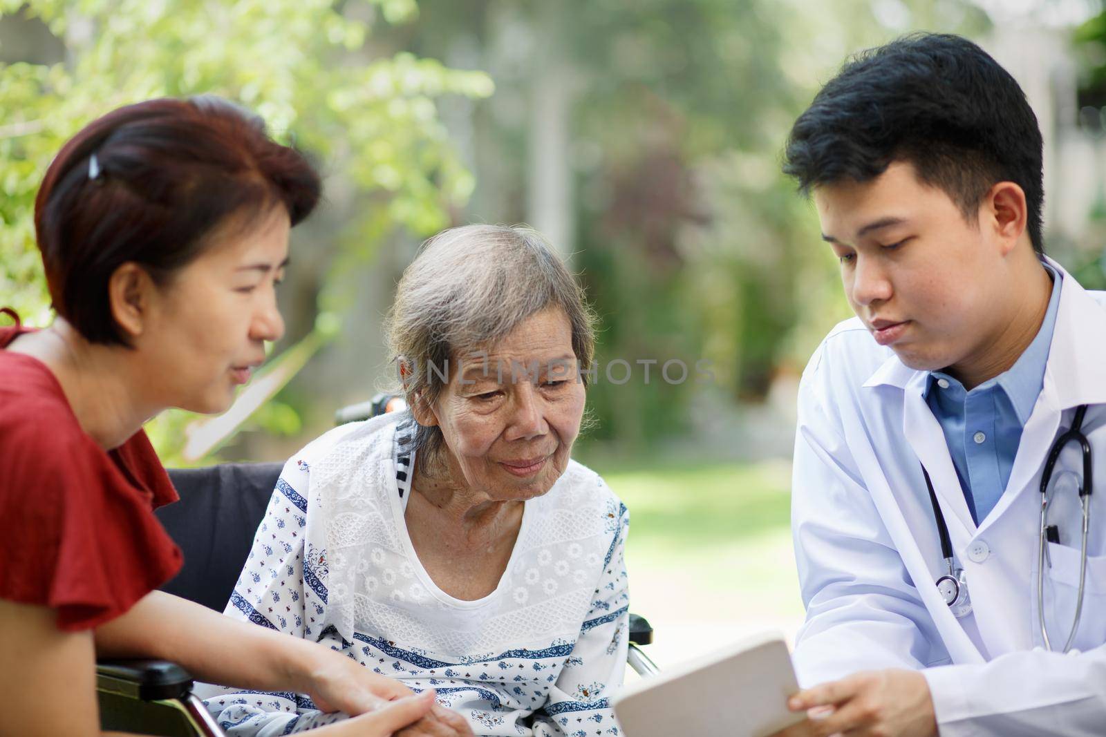  Asian doctor talking with elderly female patient on wheelchair by toa55