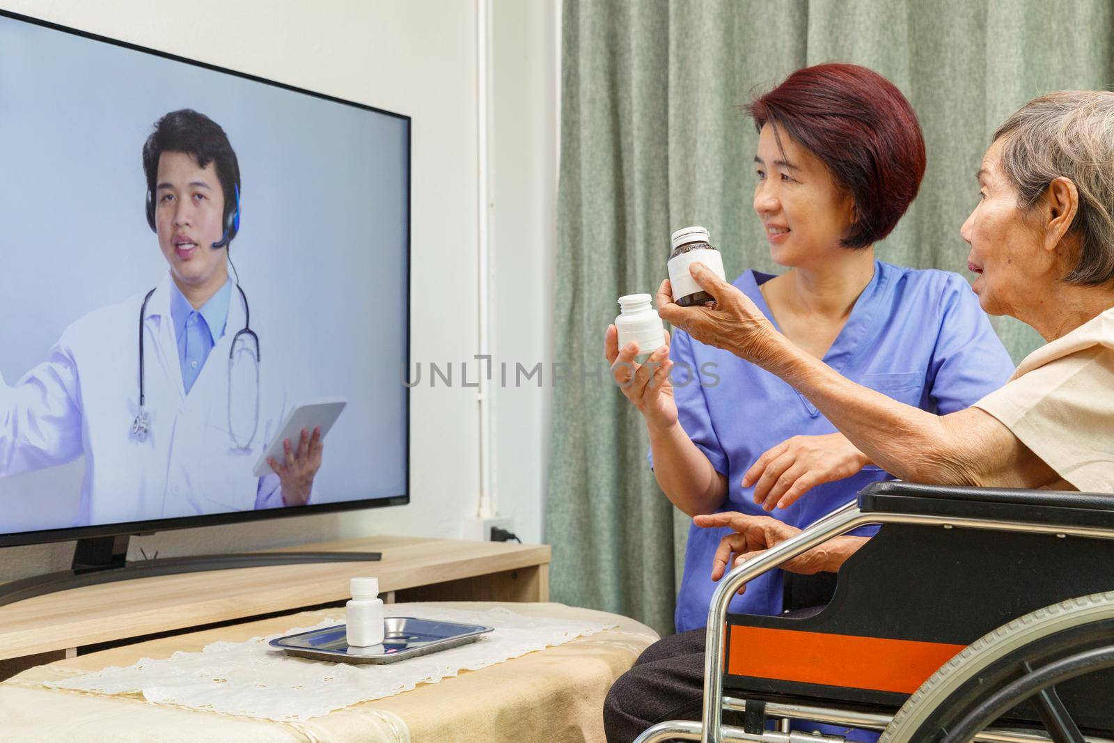 Elderly woman sit at home having online consultation with doctor on tablet computer.