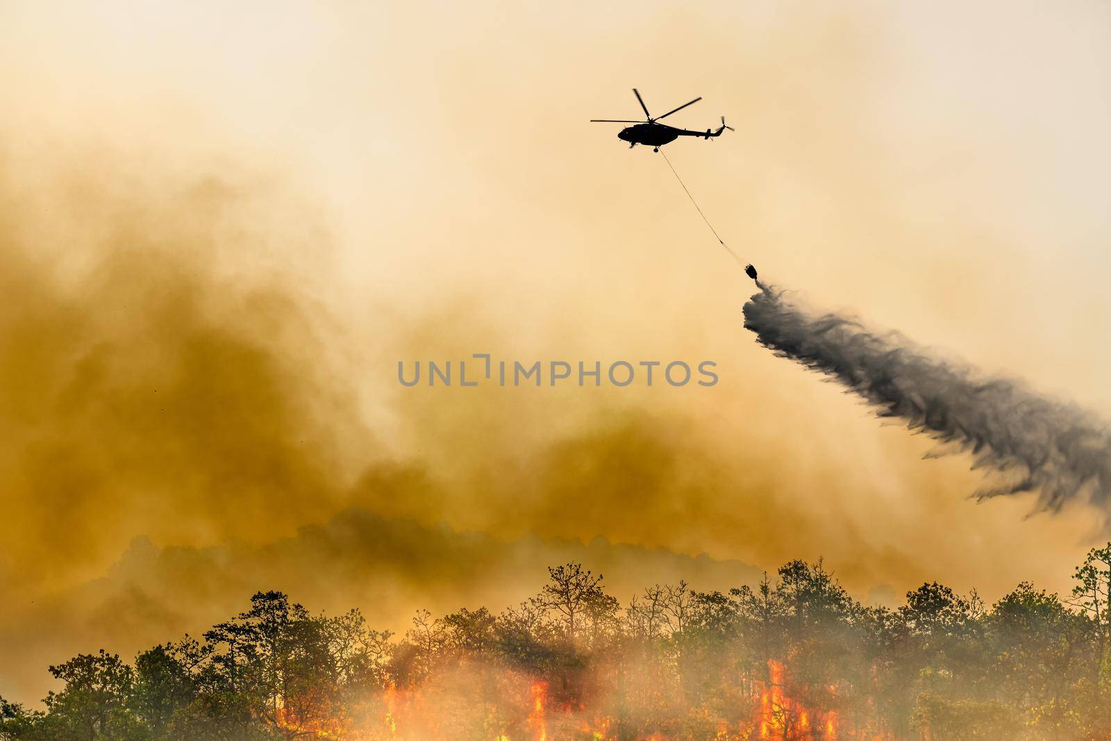 Silhouette firefithing helicopter dumps water on forest fire by toa55