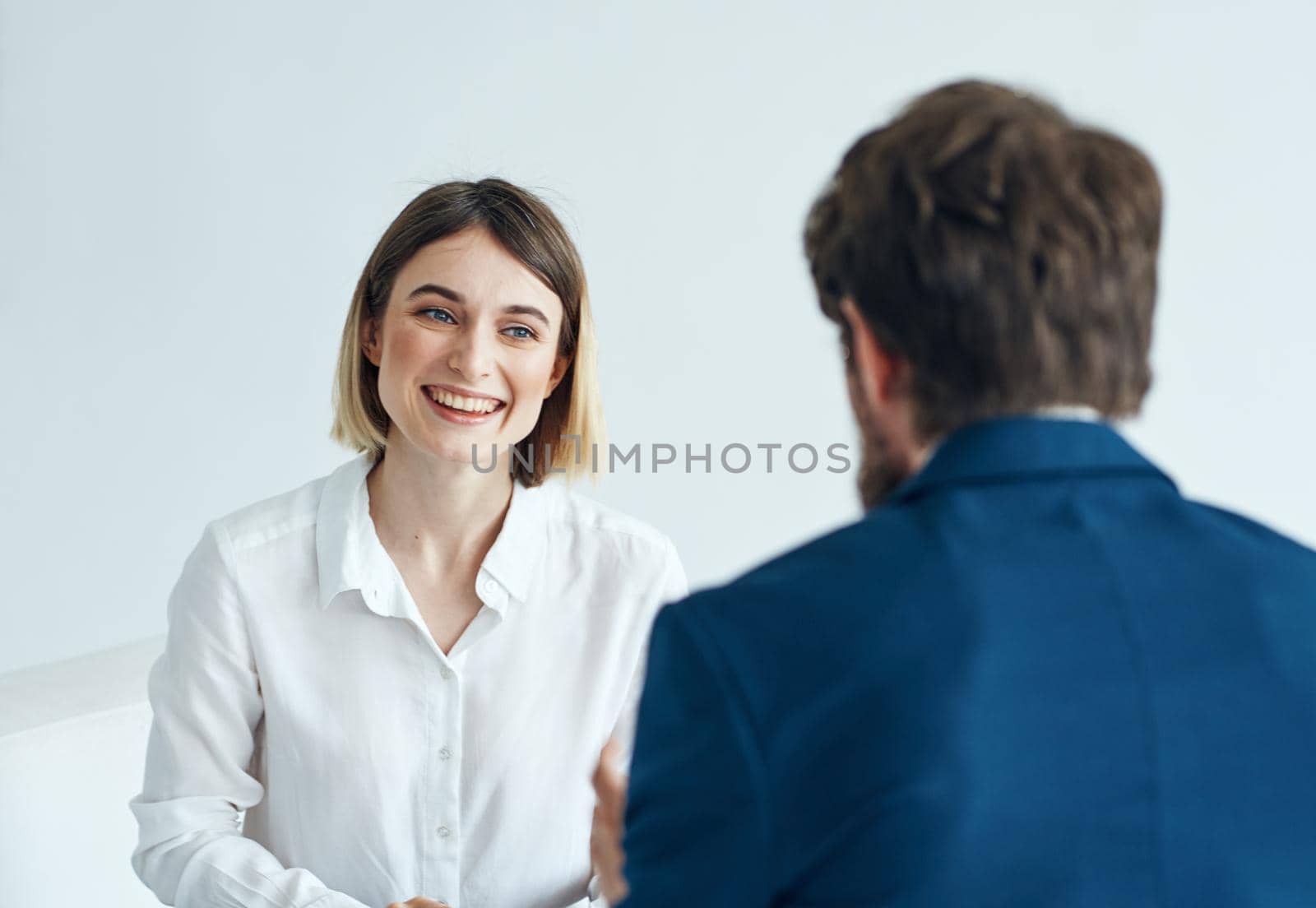 A man in a blue jacket and a woman in a shirt documents light background indoor. High quality photo