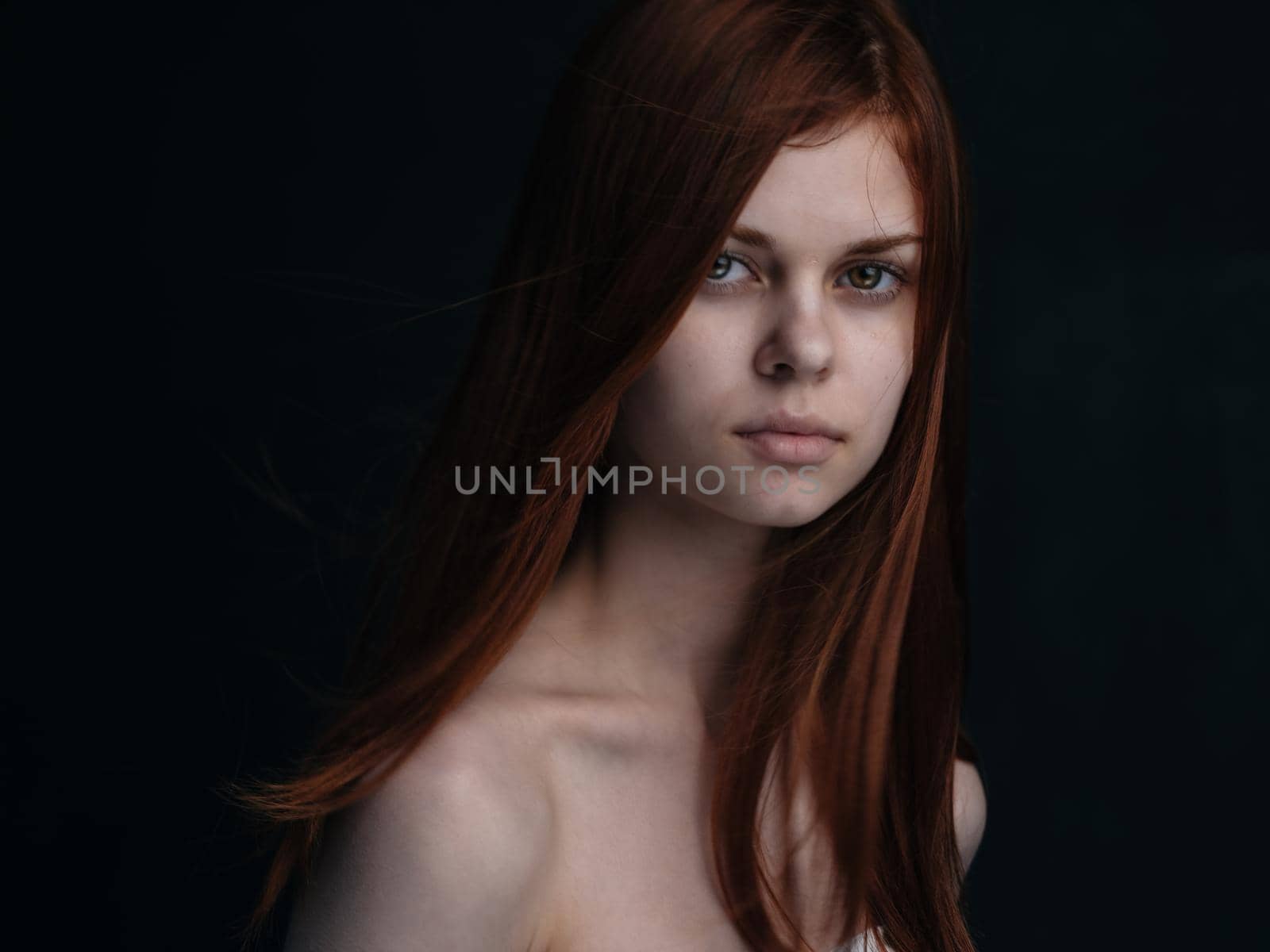 Portrait of a woman with red hair on a black background naked shoulders model by SHOTPRIME