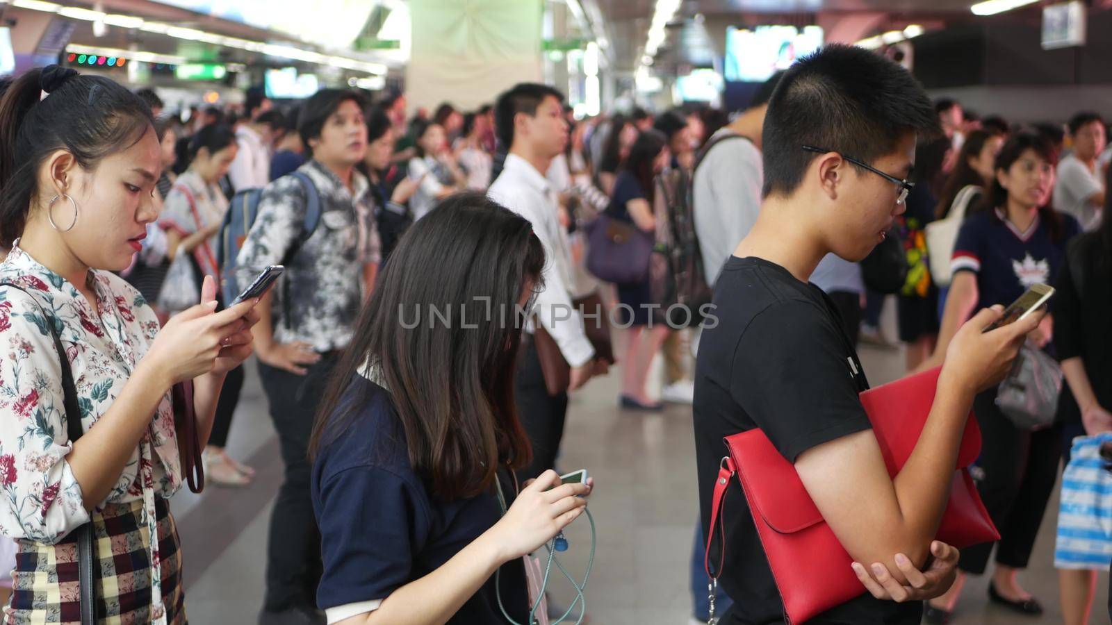 BANGKOK, THAILAND - 18 DECEMBER, 2018: Passenger at BTS Skytrain station in Bangkok Thailand, everybody looking down at smartphone while waiting for the BTS skytrain.