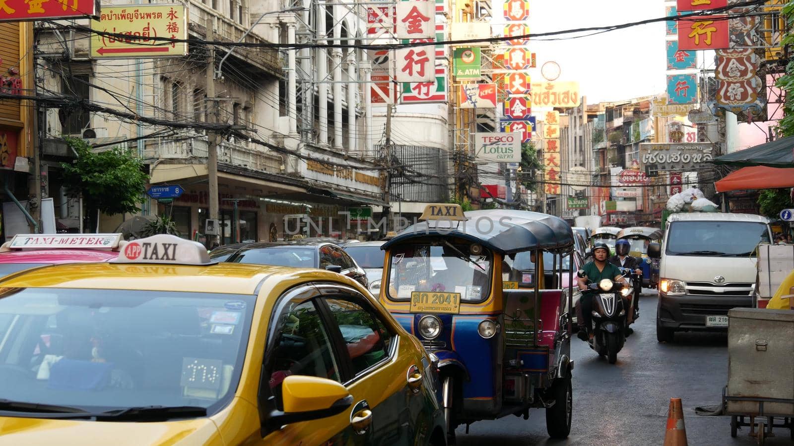 BANGKOK, THAILAND - 18 MARCH, 2019: Tuk tuks on street of Asian city. Colorful auto rickshaws riding on asphalt road on busy street of Chinatown in Bangkok