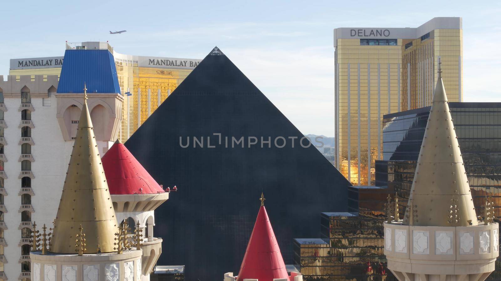LAS VEGAS, NEVADA USA - 4 MAR 2020: Excalibur castle and Luxor pyramid casino uncommon aerial view. Plane flying from McCarran airport. Mandalay Bay and Delano hotel in american gambling sin city by DogoraSun