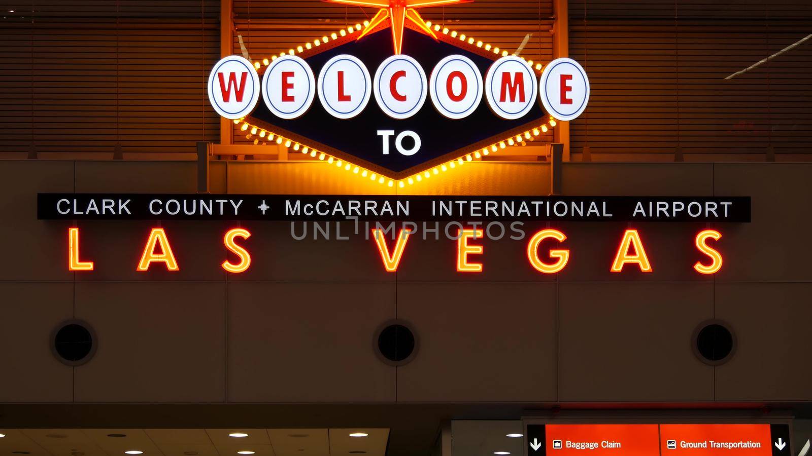 LAS VEGAS, NEVADA USA - 9 MAR 2020: Welcome to fabulous Sin City illuminated retro neon sign inside McCarran airport. Iconic greeting vintage styled signboard glowing. Gambling casino resort symbol by DogoraSun