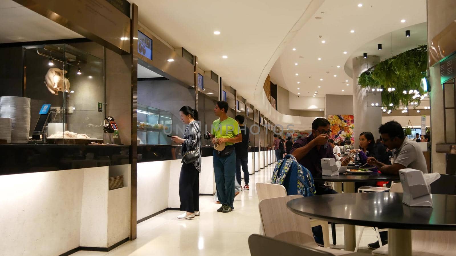 BANGKOK, THAILAND - 18 DECEMBER, 2018: People eating and bying asian thai street fast food in the food court at cafeteria in shopping mall in business centre of city.