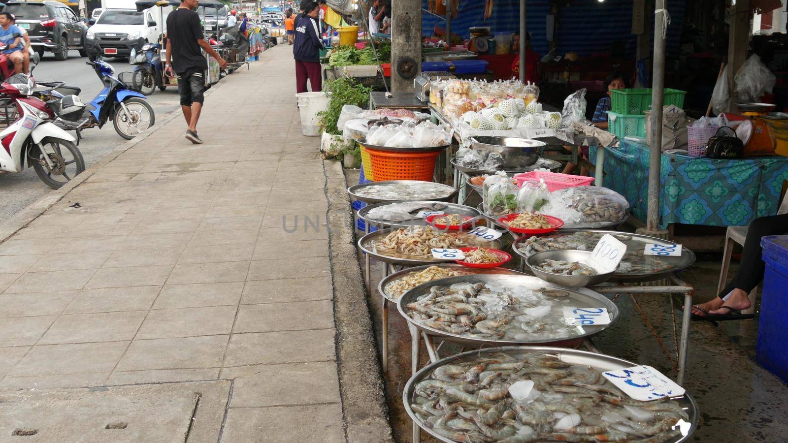 KOH SAMUI ISLAND, THAILAND - 10 JULY 2019: Food market for locals. Lively ranks with groceries. Typical daily life on the street in Asia. People go shopping for fruits vegetables, seafood and meat. by DogoraSun