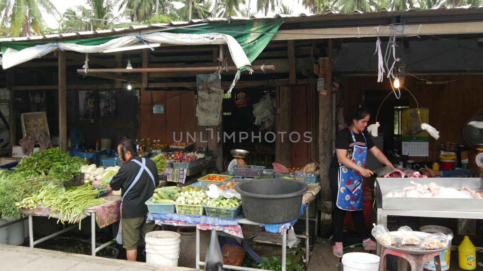 KOH SAMUI ISLAND, THAILAND - 10 JULY 2019: Food market for locals. Lively ranks with groceries. Typical daily life on the street in Asia. People go shopping for fruits vegetables, seafood and meat. by DogoraSun