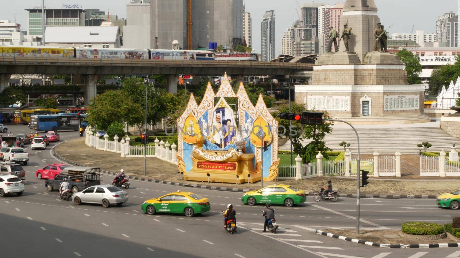 BANGKOK, THAILAND - 10 JULY, 2019: Rush hour traffic near Victory Monumet in Krungthep capital. Famous asian landmark and travel destination. Downtown modern city life. People and passengers of bts. by DogoraSun