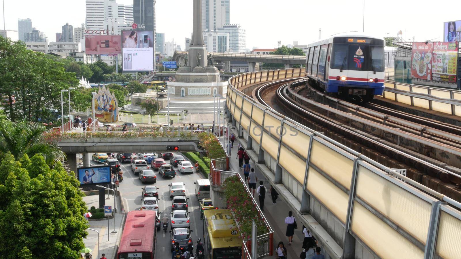 BANGKOK, THAILAND - 10 JULY, 2019: Rush hour traffic near Victory Monumet in Krungthep capital. Famous asian landmark and travel destination. Downtown modern city life. People and passengers of bts