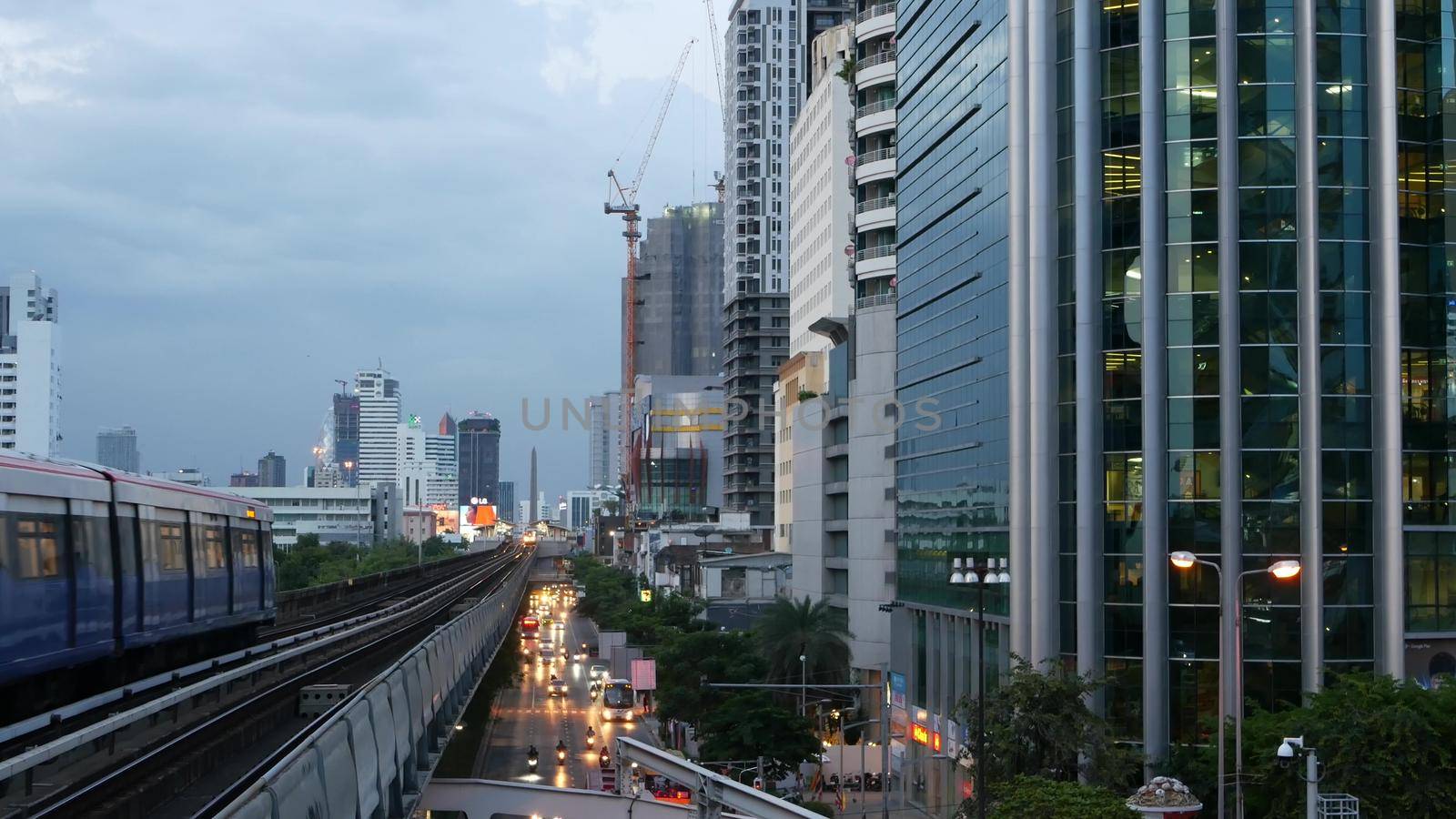 BANGKOK, THAILAND - 10 JULY, 2019: View of modern asian city from bts sky train platform. Train on metro rail road station. Public transportation in Krungtep downtown. Evening steet traffic in Asia. by DogoraSun