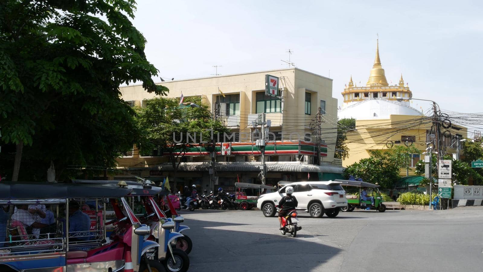BANGKOK, THAILAND - 11 JULY, 2019: Rush hour traffic near Wat Saket in capital. Famous asian landmark and travel destination. Ancient religious monastery and public transport on the road in downtown. by DogoraSun