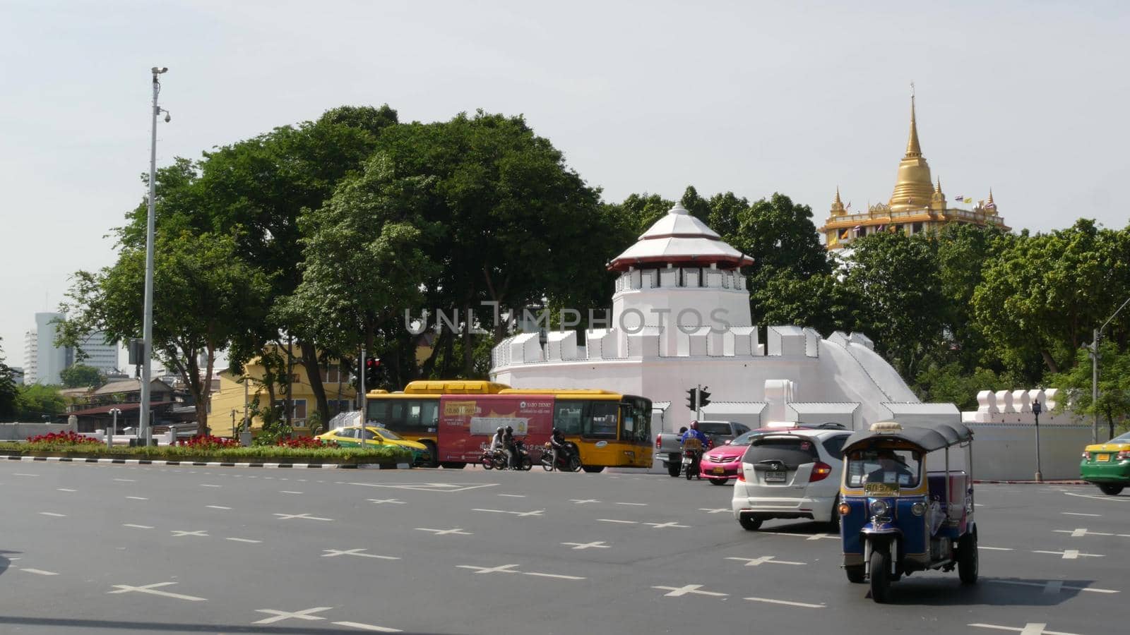 BANGKOK, THAILAND - 11 JULY, 2019: Rush hour traffic near Wat Saket in capital. Famous asian landmark and travel destination. Ancient religious monastery and public transport on the road in downtown