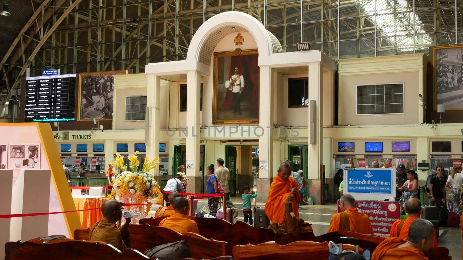 BANGKOK, THAILAND - 11 JULY, 2019: Hua Lamphong railroad station, state railway transport infrastructure SRT. Buddhist holy Monk in traditional orange robe. Monks yellow religious clothes among people by DogoraSun