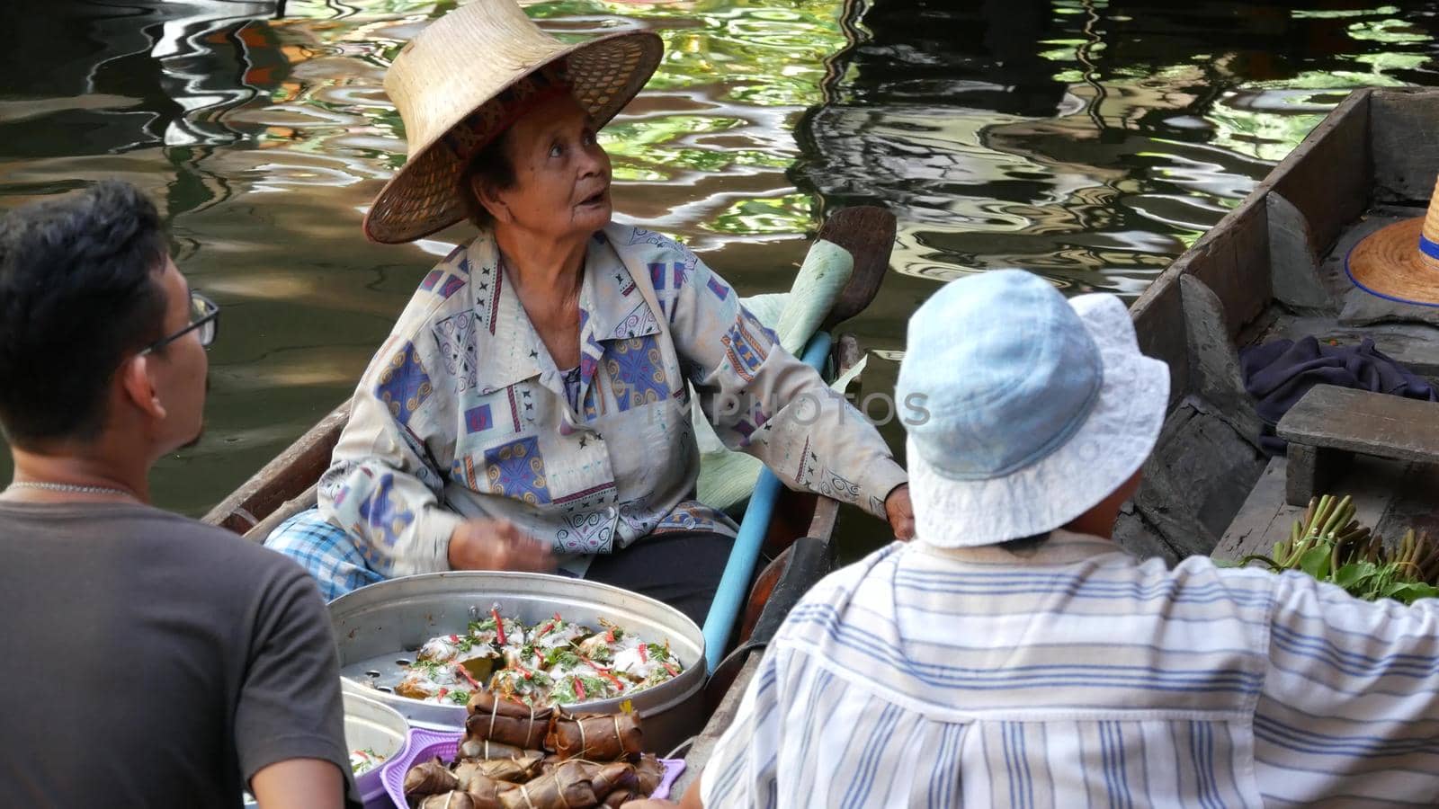 BANGKOK, THAILAND, 13 JULY 2019 Lat Mayom floating market. Traditional classic khlong river canal, local women in long-tail boats with oriental thai cusine assortment. Iconic asian street food selling by DogoraSun