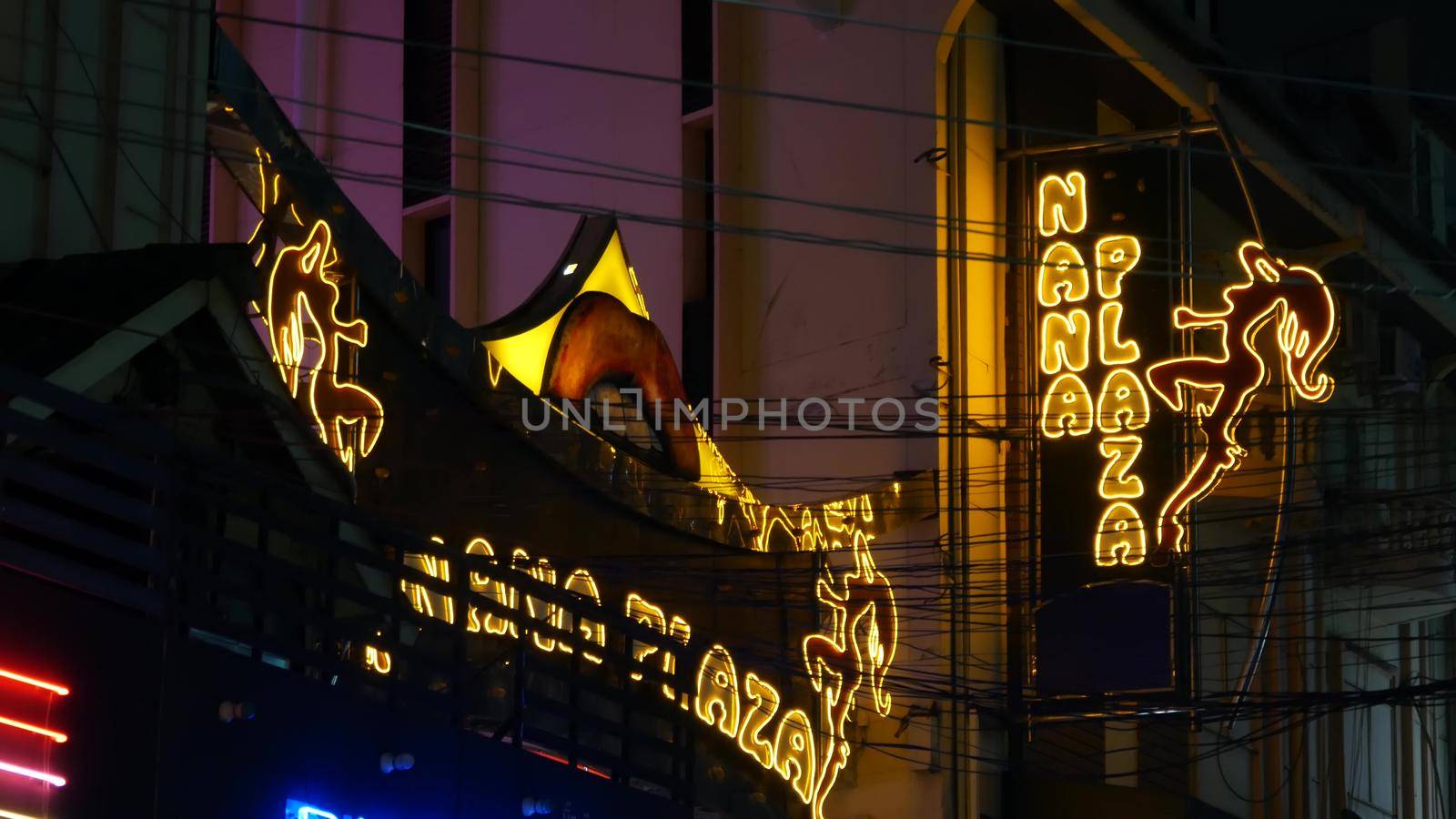 BANGKOK, THAILAND,13 JULY 2019 Vivid neon signs glowing, Nana Plaza street. Nightlife in erotic Red light district soi. Illuminated bar and adult go-go show club. Night life tourist entertainment