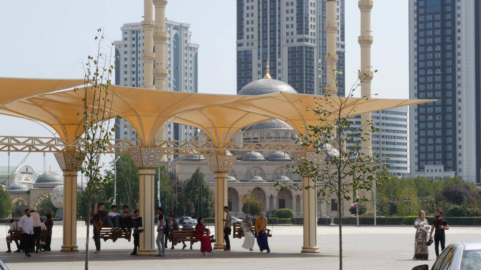 GROZNY, THE CHECHEN REPUBLIC OF ICHKERIA, CAUCASUS, RUSSIA, 6 SEPTEMBER 2019 Day of Civil Concord and Unity, The Heart of Chechnya. Happy young people, joyful muslim men and women having fun on swings by DogoraSun