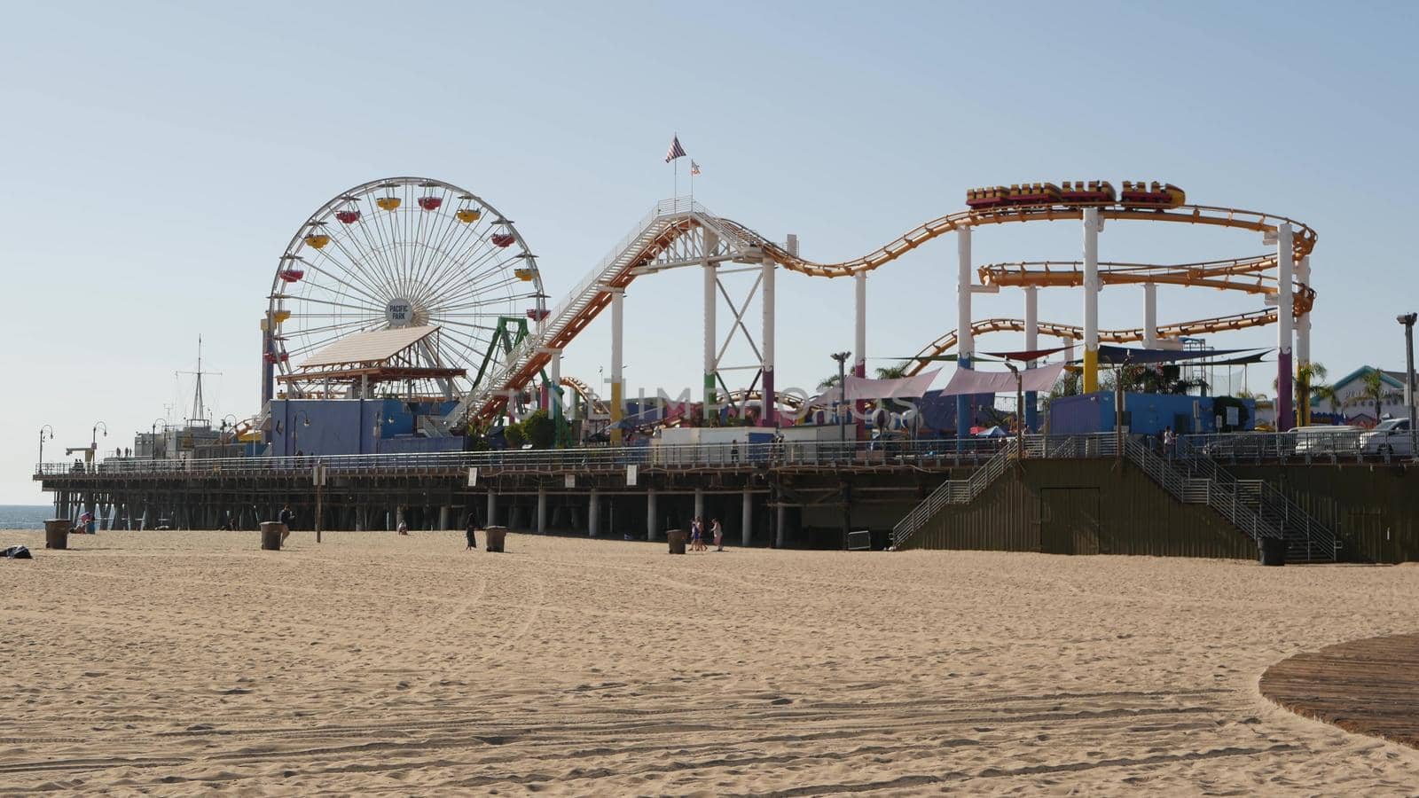 SANTA MONICA, LOS ANGELES CA USA - 28 OCT 2019: Famous classic california summertime symbol, pacific ocean beach resort. Iconic colorful retro ferris wheel and roller coaster, amusement park on pier.