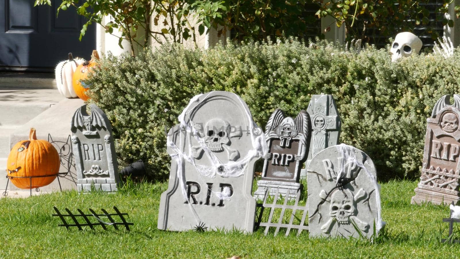 LOS ANGELES, CALIFORNIA, USA - 29 OCT 2019: Scary festival decorations of a house, Happy Halloween holiday. Classic garden with Pumpkin, Bones and Skeleton. Traditional party decor. American culture by DogoraSun