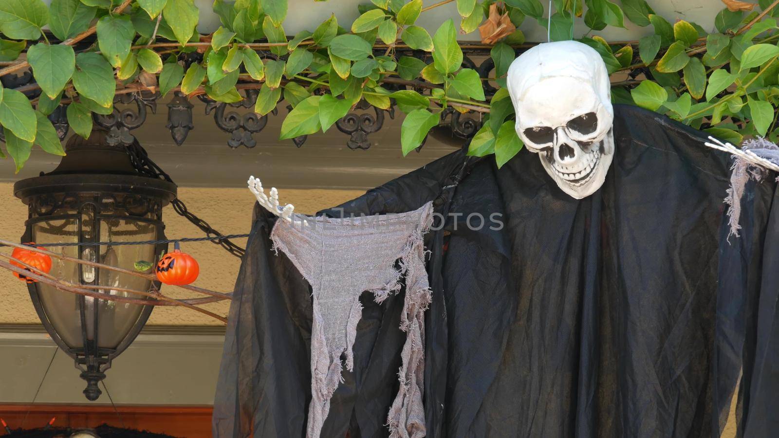 LOS ANGELES, CALIFORNIA, USA - 29 OCT 2019: Scary festival decorations of a house, Happy Halloween holiday. Classic garden with Pumpkin, Bones and Skeleton. Traditional party decor. American culture.