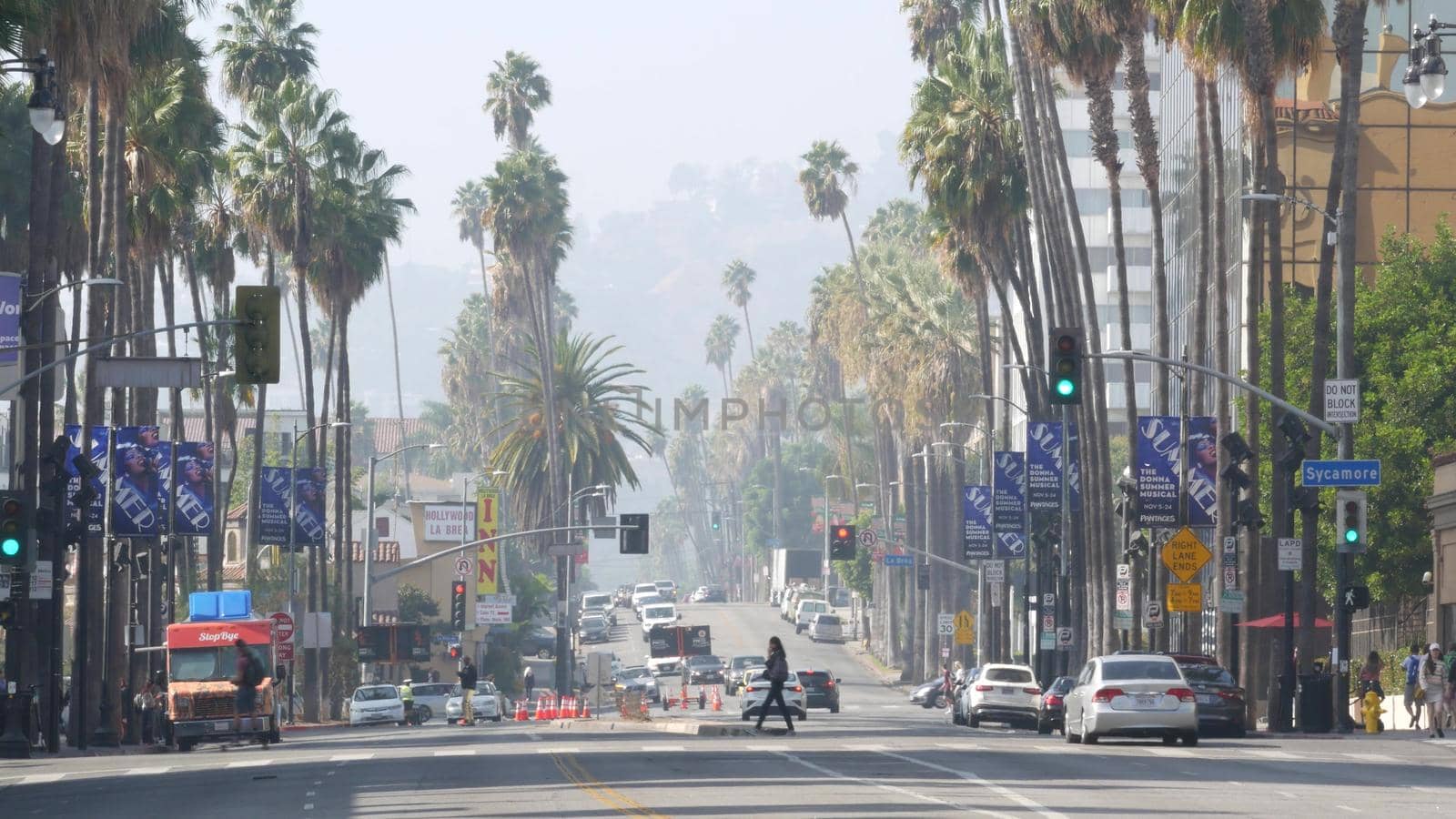 LOS ANGELES, CALIFORNIA, USA - 7 NOV 2019: Walk of fame promenade, Hollywood boulevard in LA city. Pedastrians walking on sidewalk of street. Entertainment and cinema industry iconic tourist landmark.