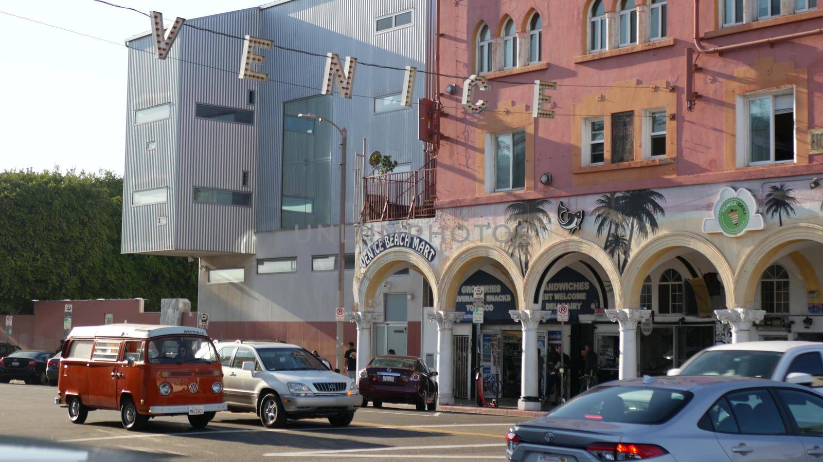 LOS ANGELES CA USA - 16 NOV 2019: California summertime Venice beach aesthetic. Iconic retro sign hanging on street. Famous symbol and travel destination. Letters over the road with cars and people.