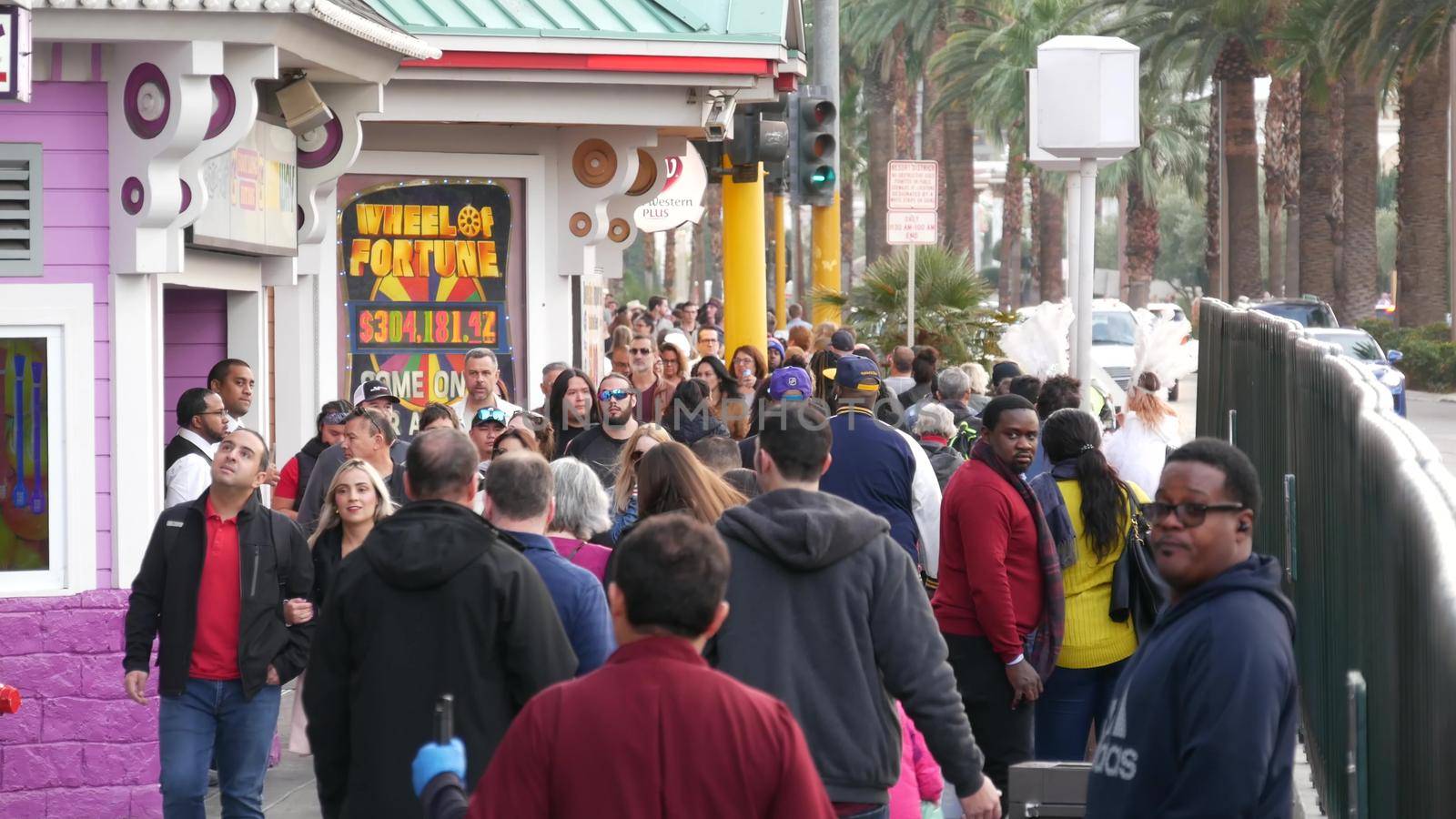 LAS VEGAS, NEVADA USA - 13 DEC 2019: People on pedestrian walkway. Multicultural men and women walking on city promenade. Crowd of citizens on sidewalk. Diversity of multiracial faces in metropolis by DogoraSun