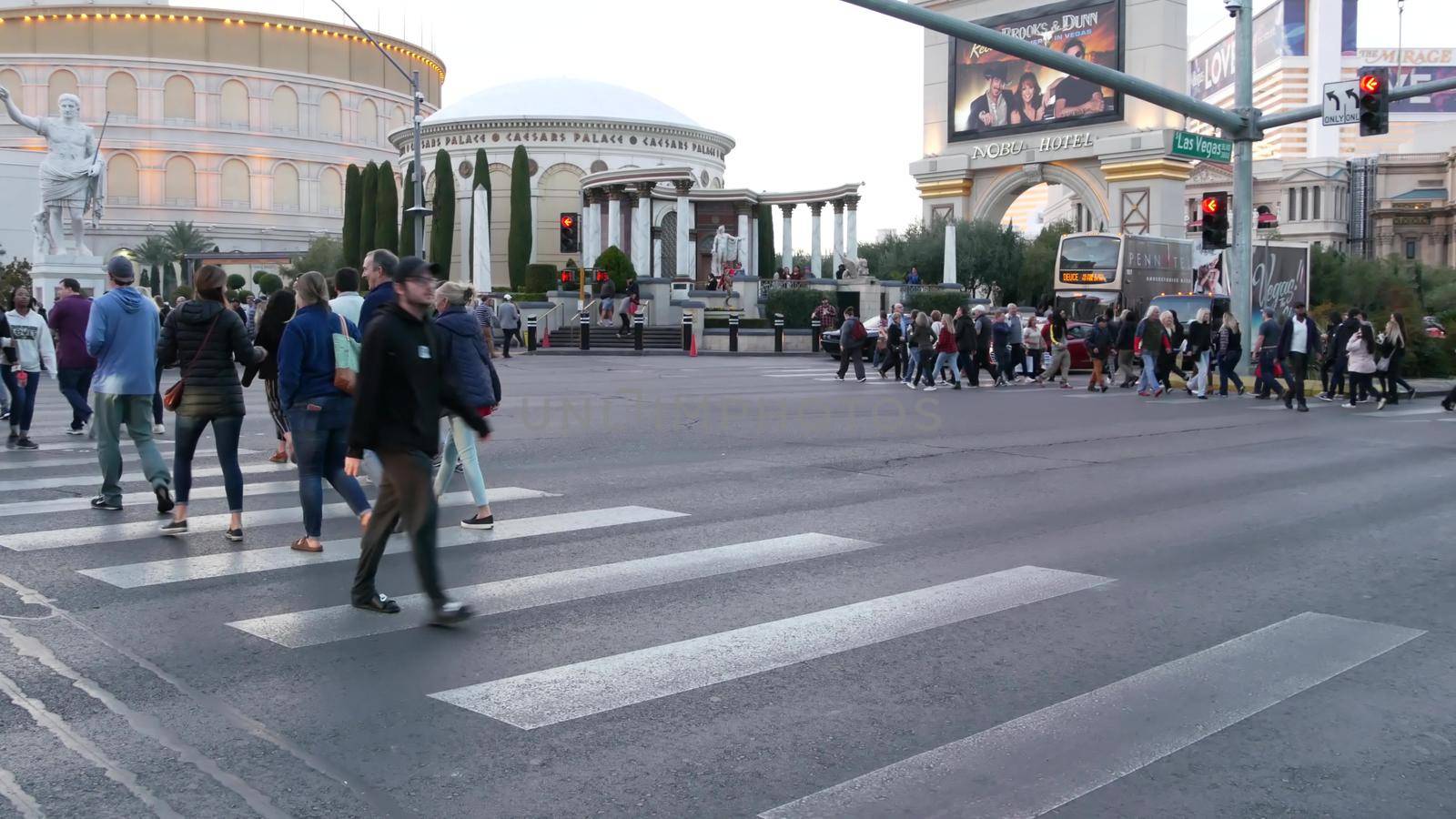 LAS VEGAS, NEVADA USA - 13 DEC 2019: People on pedestrian walkway. Multicultural men and women walking on city promenade. Crowd of citizens on sidewalk. Diversity of multiracial faces in metropolis by DogoraSun