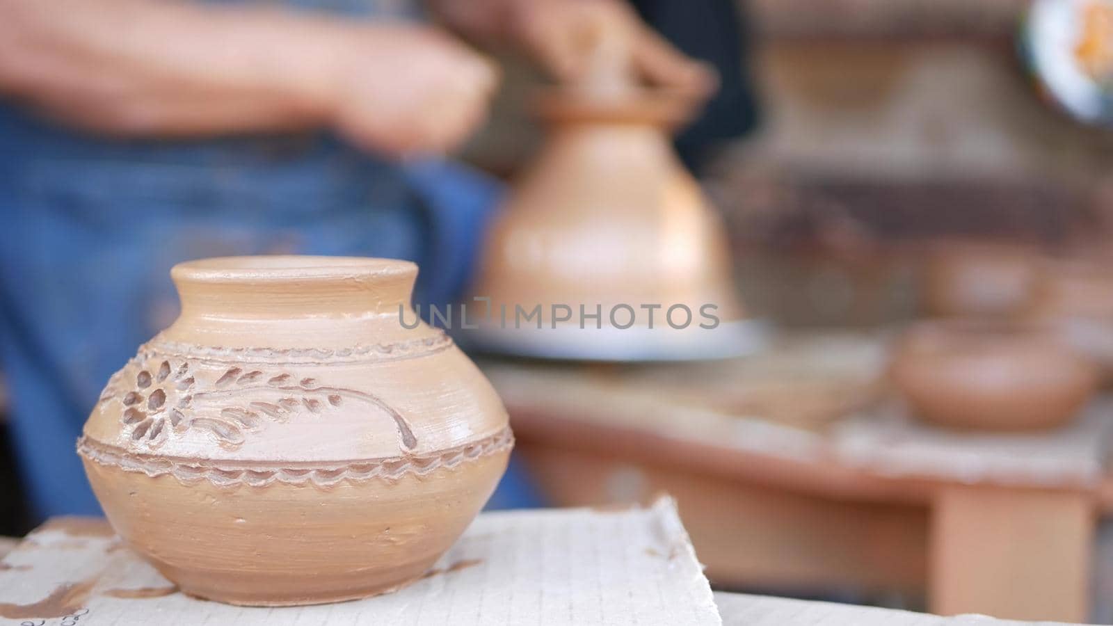 SAN DIEGO, CALIFORNIA USA - 5 JAN 2020: Potter working in mexican Oldtown, raw clay on pottery wheel. Man's hands, ceramist in process of modeling handcrafted clayware. Craftsman creating ceramic.