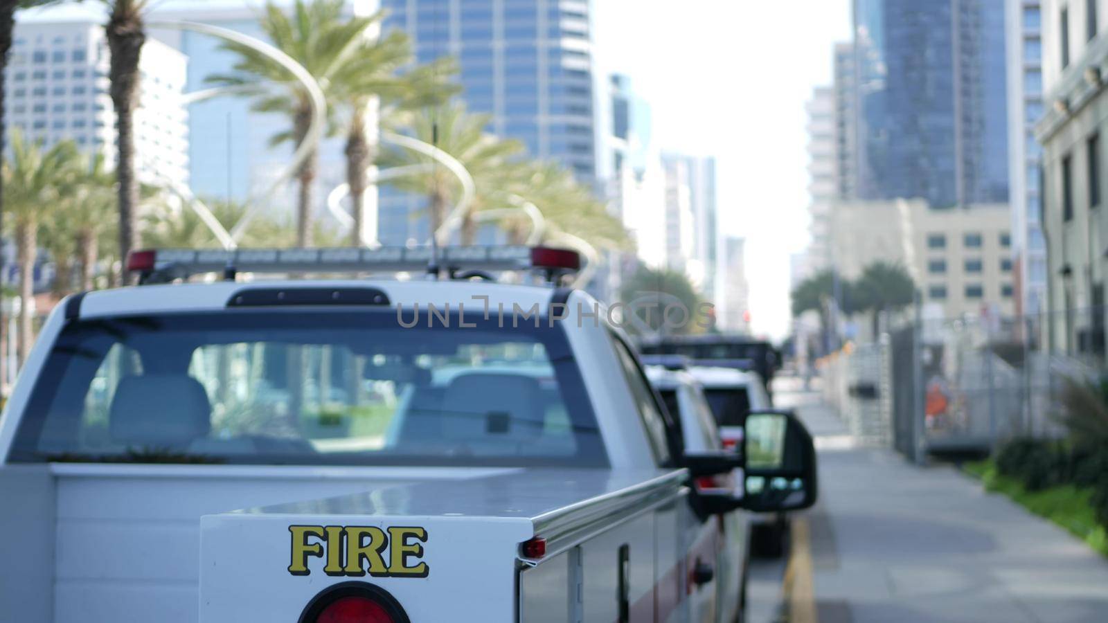 SAN DIEGO, CALIFORNIA USA - 15 JAN 2020: Fire department trucks and Sheriff's car with emergency sirens parked on Broadway. Firefighters vehicles in downtown. Fire engine for rescue and public safety.